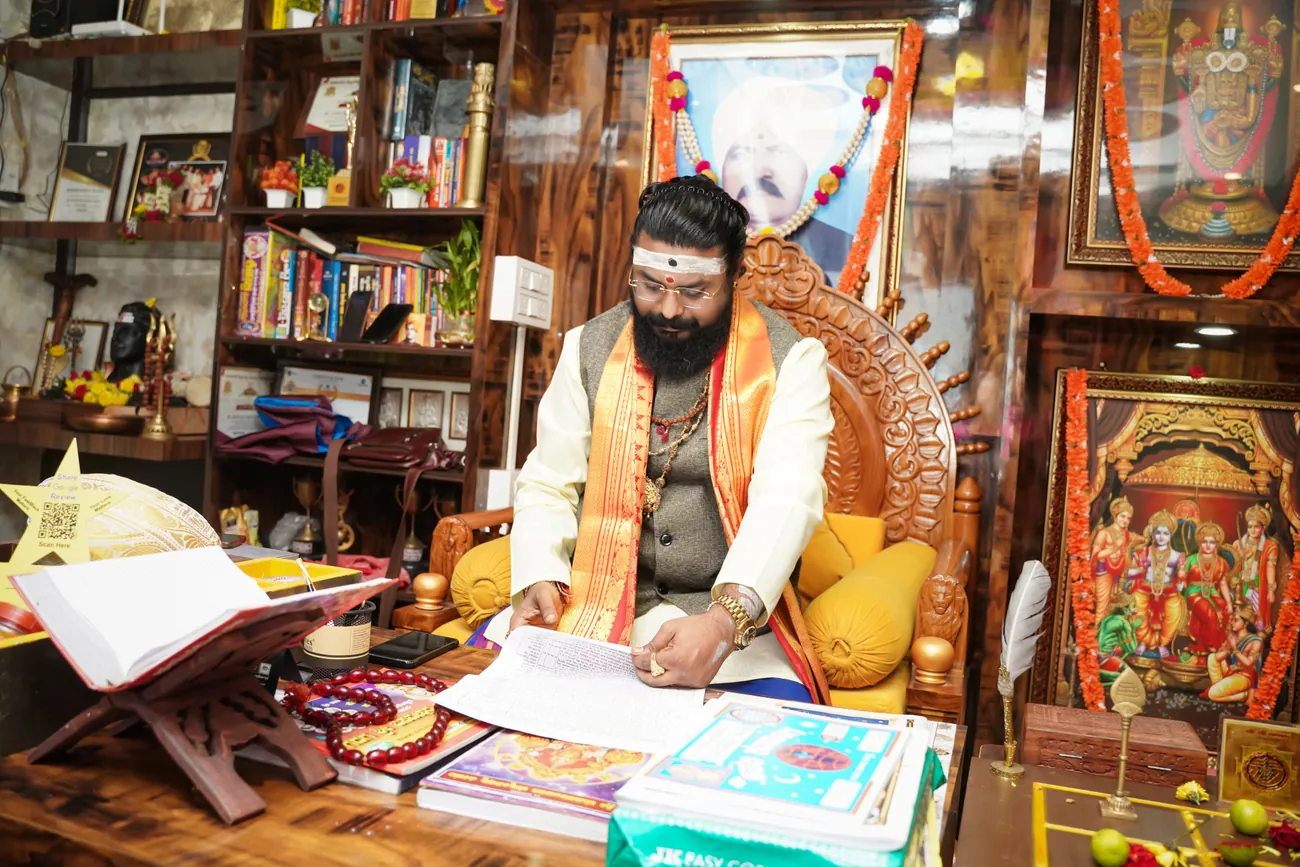 Arun Sharma Guruji working over a chart at his desk in Whitefield
